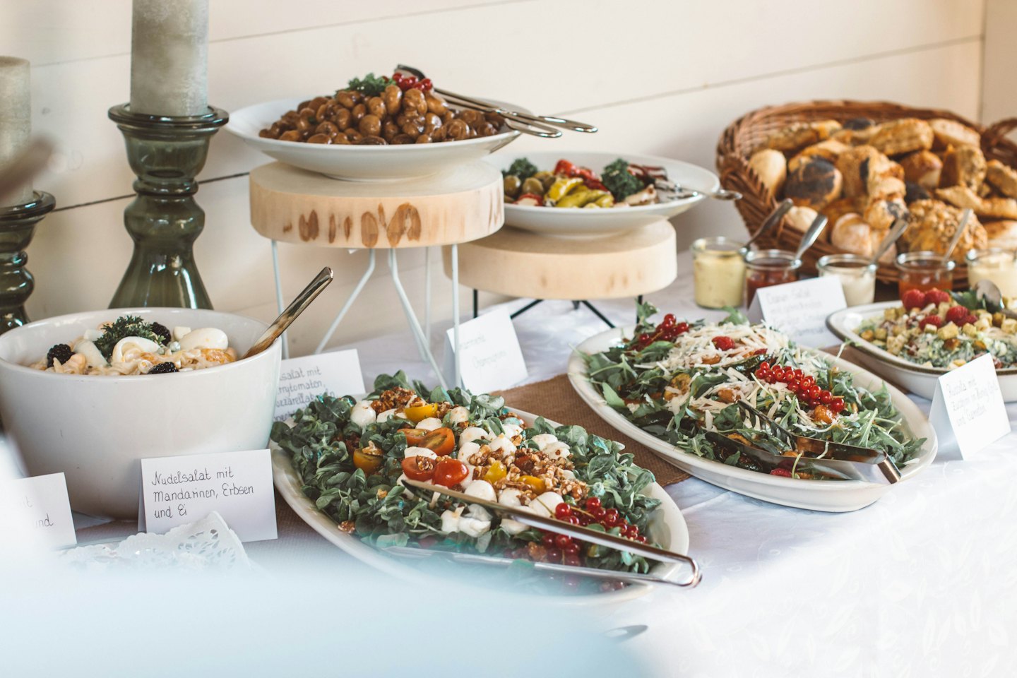 Buffettisch mit Salaten, Brötchen und Gebäck.